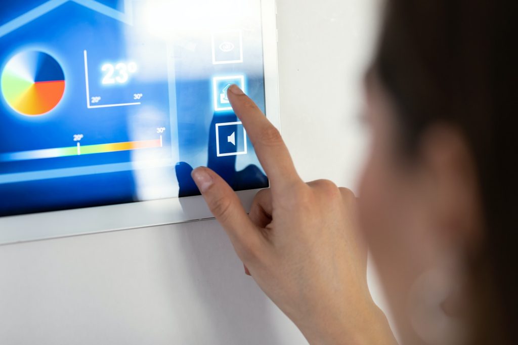 Young woman using the home automation system on digital tablet to regulate the temperature.